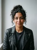 Photo de la personne transformée : une femme aux cheveux bruns bouclés en veste de cuir noire
